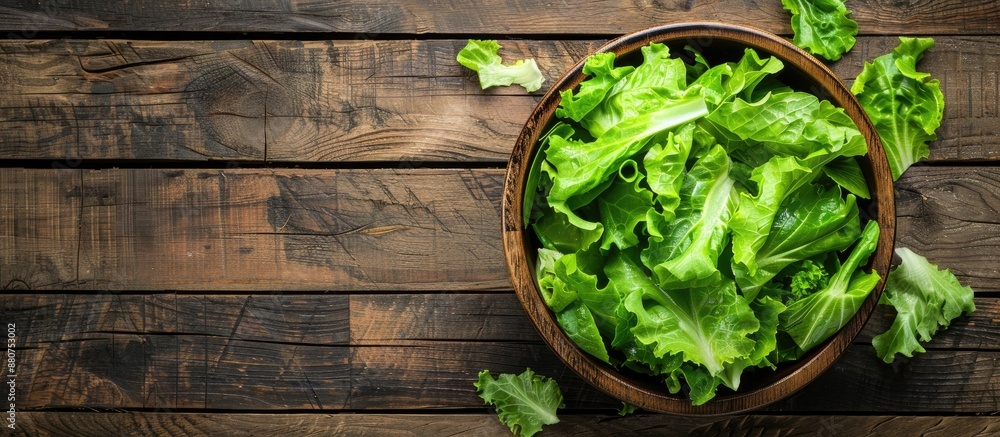 Poster top down view of a fresh green lettuce salad on a rustic wooden table ideal for text placement healt