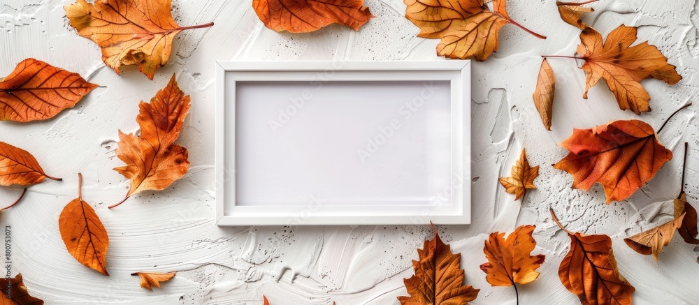 Poster white photo frame with autumn dried leaves on an autumn background creates a flat lay top view ideal