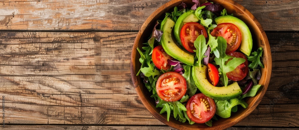 Poster top view of a salad featuring avocado tomato and fresh veggies on a wooden backdrop with ample copy 