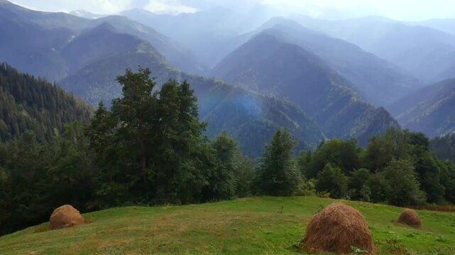 Haystacks against the background of mountains. 