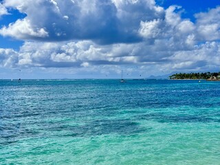 seascape of Guadeloupe in the French West Indies with a view of a lagoon with turquoise waters and a rocky coast with tropical vegetation in the background on a sunny day
