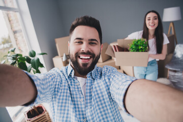 Photo of two young partners make selfie hold box package relocating moving new modern flat indoors