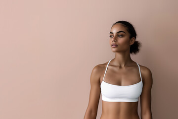 Obraz premium Portrait of a young fitness model in athletic fashion, set against a vibrant pink backdrop, radiating confidence and style.