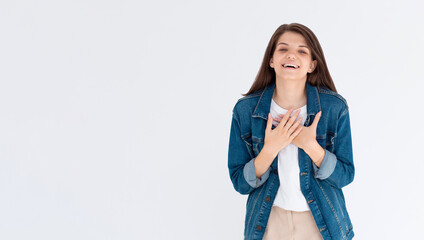 Hilarious joke. Portrait of happy optimistic girl with long hair in white shirt holding belly and laughing out loud, amused by silly funny anecdote
