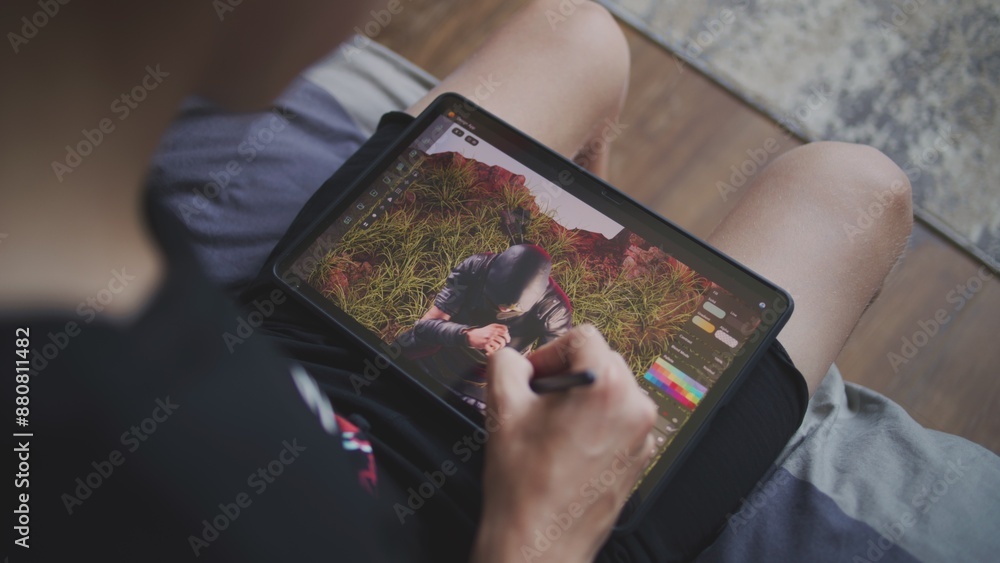 Aufkleber boy with digital stylus and tablet in hands sits in cozy room and draws 3d model. teenager creates n