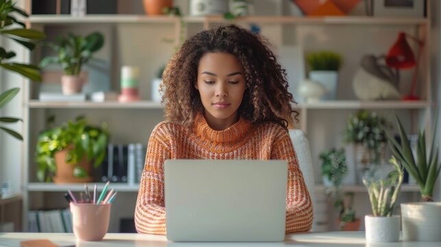 Young woman excelling in a home office setup, with a laptop and organized workspace, symbolizing remote work success.