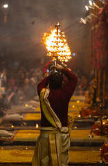 Ganga aarti, Portrait of young priest performing holy river ganges evening aarti at assi ghat in traditional dress with hindu rituals at dashashwamedh ghat.