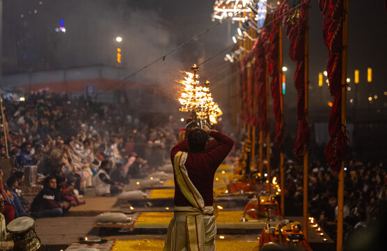 Ganga aarti, Portrait of young priest performing holy river ganges evening aarti at assi ghat in traditional dress with hindu rituals at dashashwamedh ghat.