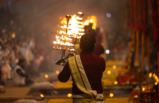 Ganga aarti, Portrait of young priest performing holy river ganges evening aarti at assi ghat in traditional dress with hindu rituals at dashashwamedh ghat.