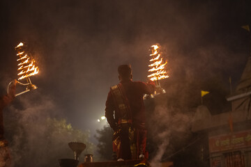 Ganga aarti, Portrait of young priest performing holy river ganges evening aarti at assi ghat in traditional dress with hindu rituals