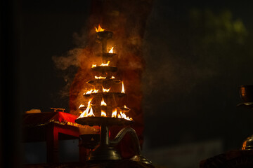 	
Ganga aarti, Fire flame at night with dark background during the ganga aarti rituals at river...