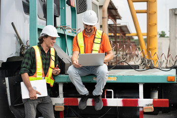 Portrait Hispanic latin engineer man use tablet computer and caucasian engineer man use walkie talkie with truck at construction site
