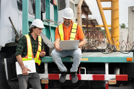 Portrait Hispanic latin engineer man use tablet computer and caucasian engineer man use walkie talkie with truck at construction site