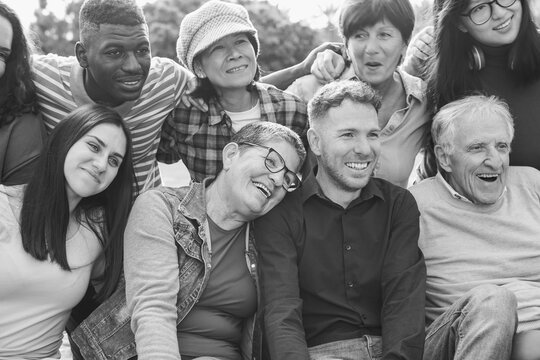Crowd of multiracial people having fun hugging each others at city park - Social inclusion, collective and multi generational community concept