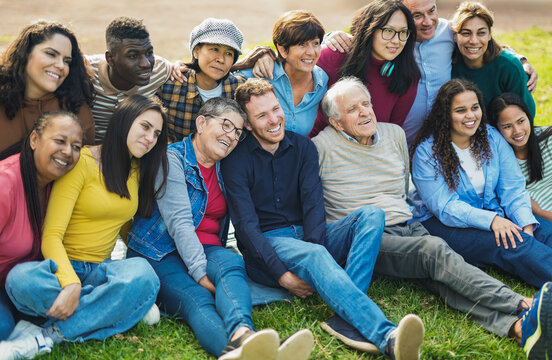 Crowd of multiracial people having fun hugging each others at city park - Social inclusion, collective and multi generational community concept