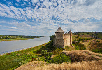 Khotyn fortress built in the 14th century. View of top of the fortress wall and towers among the hills closeup on background of Dniester river and its left bank at early springtime