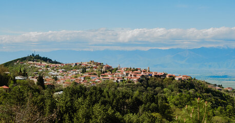 Signahi Signagi city town in Georgia. Sunny weather with clouds and mountains on a background. Roofs and houses on big hill. Travel in Sakartvelo, Georgia. 