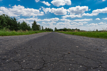 Landscape with old asphalt road through meadows on flatlands in Poland