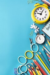 Pastel blue background, right side with school supplies scissors, pencils, alarm clock, copy space for "Back to School" text. Flat lay, top view.