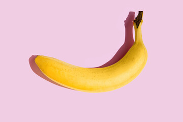 Single banana on a pink background