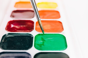 A watercolor palette with a brush in it, perfect for painting