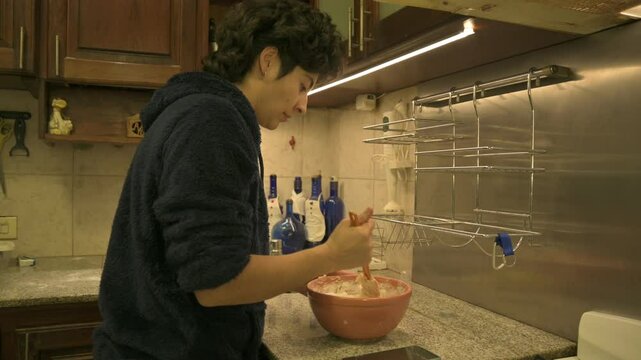 Persona a&ntilde;adiendo harina a la mezcla para amasar