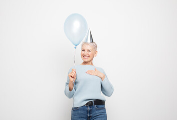 Portrait of elderly lady holding blue balloon having fun