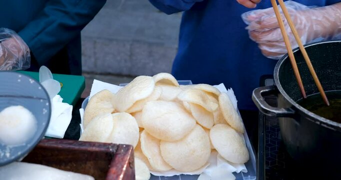Prawn Crackers or Shrimp Chips with ketchup served on parchment paper, Fresh Krupuk on dark background.