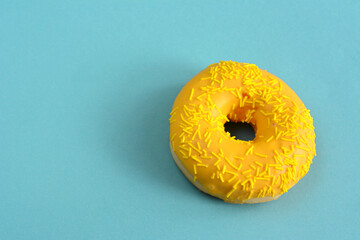 a donut with yellow frosting and yellow icing with yellow sprinkles