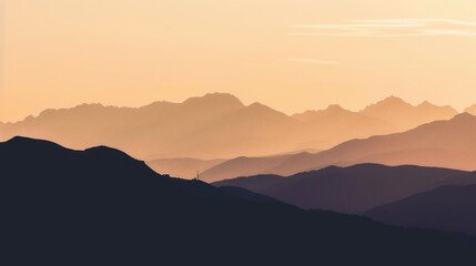 Obraz premium Silhouette of mountains during sunset with a gradient of warm colors and layered peaks.