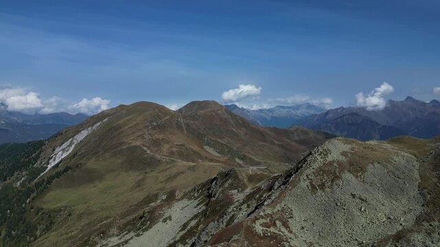Luftaufnahme des Penser Jochs im Herbst bei Sonnenschein mit ein paar Wolken