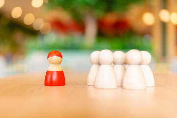 Red wooden figure and group of other wooden figure to talking influence, empowerment and inspiration for crowd. Leader with influence, leadership and successful