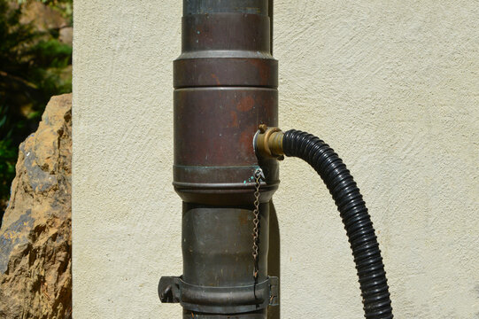 Wasserdieb aus Kupfer mit Messing-Auslass in einem kupfernen Regenfallrohr zur Ausleitung von Regenwasser in eine Regentonne