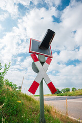 Rail Road Traffic Light and Sign Near a Country Road