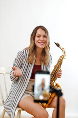 girl with saxophone talking to cell phone in a live show