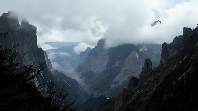 The rugged beauty of a mountain pass with jagged peaks and rolling clouds in the background.