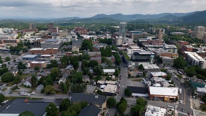 Fototapeta premium City skyline of Asheville, NC at the base of the Blue Ridge Mountains in North Carolina, a living and vacation destination in the Southern, United States showing architecture of buildings and streets