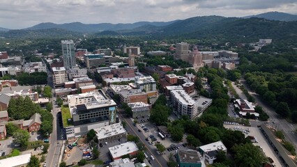 Fototapeta premium City skyline of Asheville, NC at the base of the Blue Ridge Mountains in North Carolina, a living and vacation destination in the Southern, United States showing architecture of buildings and streets