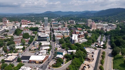 Fototapeta premium City skyline of Asheville, NC at the base of the Blue Ridge Mountains in North Carolina, a living and vacation destination in the Southern, United States showing architecture of buildings and streets