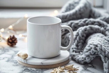 White coffee mug placed on an elegant marble coaster, beside a soft fabric texture of a grey knitted blanket.