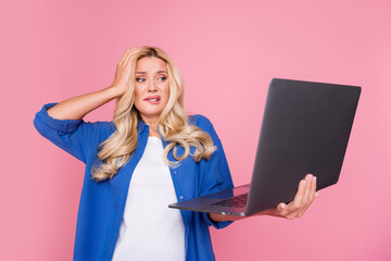 Photo of pretty uncertain lady dressed blue jacket reading modern device empty space isolated pink...