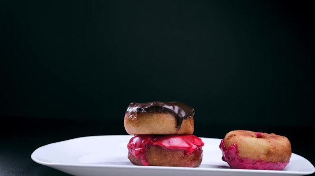 sprinkle donuts with powdered sugar on a black background