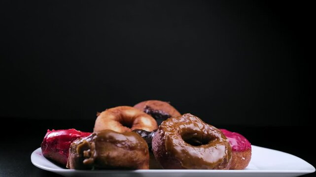 sprinkle donuts with powdered sugar on a black background