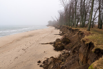 Coastal erosion by storm action. The seashore crumbles due to the wind