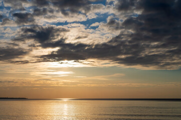 Sunset over the sea. Reflection of sunlight in the sea waves. The sky in the sunset rays. Baltic Sea.