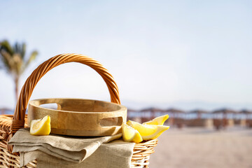 Empty summer picninc basket on sunny tropical sandy beach with copy space for products and objects. Summer concept  background.
