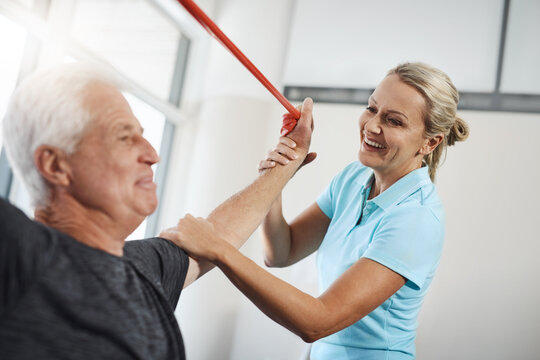 Physical therapy, resistance band and senior patient with medical support, help and happy for healthcare services. People, doctor or chiropractor with elderly client, stretching and shoulder strength