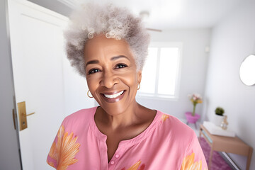 Close up photo of a happy senior African American woman in pastel shirt taking a selfie