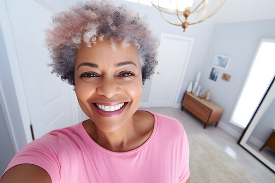 Close up photo of a happy senior African American woman in pastel shirt taking a selfie