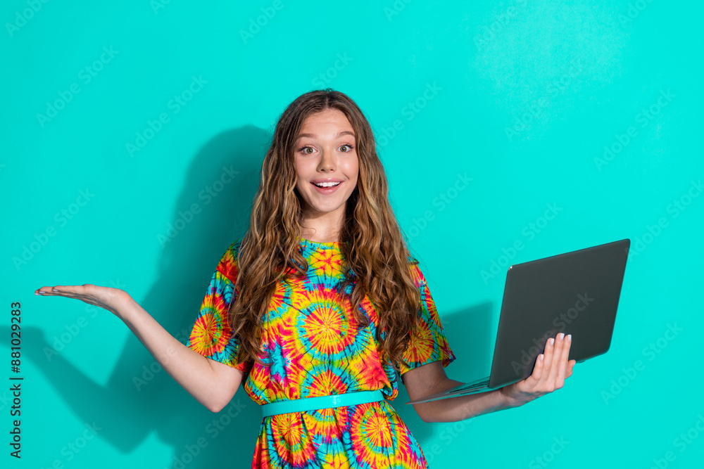 Poster Photo portrait of lovely teen lady netbook hold empty space dressed stylish colorful garment isolated on cyan color background